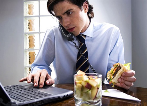 Close-up of a businessman talking on the telephone while using a laptop