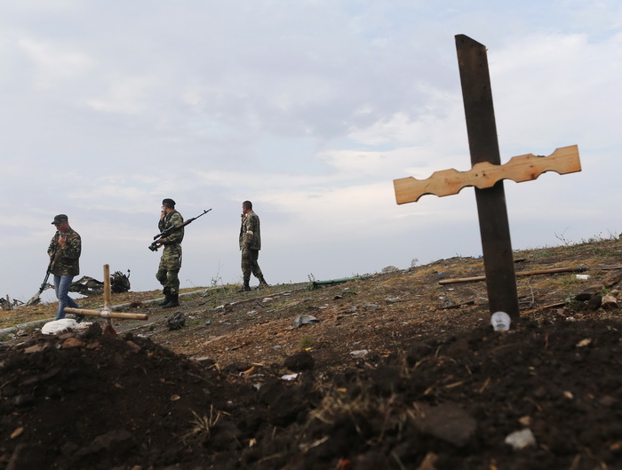 Pro-Russian separatists walk past an unmarked grave at Savur-Mohyla, a hill east of the city of Donetsk, August 28, 2014. Ukrainian President Petro Poroshenko said on Thursday that Russian forces had entered his country and the military conflict was worsening after Russian-backed separatists swept into a key town in the east. REUTERS/Maxim Shemetov (UKRAINE - Tags: POLITICS CIVIL UNREST CONFLICT MILITARY)