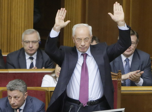 FILE - In this Tuesday, Dec. 3, 2013 file photo Ukraine's Prime Minister Mykola Azarov, right, gestures to lawmakers in parliament during the session in Kiev, Ukraine. Ukrainian President Viktor Yanukovich has accepted the resignation of Azarov and his cabinet. The cabinet will continue to work until a new government is formed. In back-to-back moves to try resolving Ukraine's political crisis, the prime minister submitted his resignation Tuesday Jan. 28, 2014 and parliament repealed anti-protest laws that had set off violent clashes between protesters and police. (AP Photo/Efrem Lukatsky, FIle)